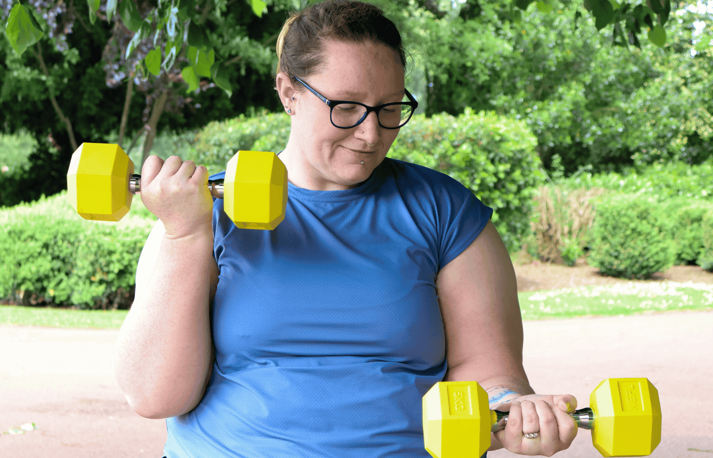 Rhiannon Cooper training at outside with yellow dumbbells