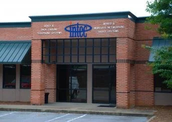 Exterior of a brick building with large glass doors and windows, displaying the logo for INRO in blue above the entrance.