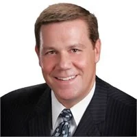 Portrait of a smiling man in a suit and tie.