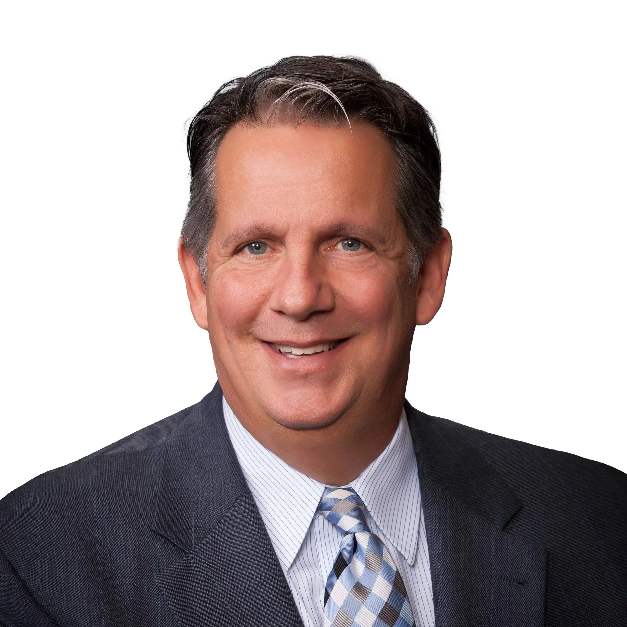 Professional headshot of a middle-aged man with dark hair, blue eyes, wearing a dark suit, white shirt, and patterned tie, smiling against a white background.