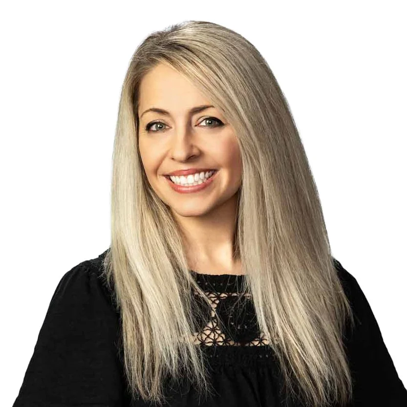 A woman with long blonde hair, smiling, wearing a black top with lace detail, against a plain white background.
