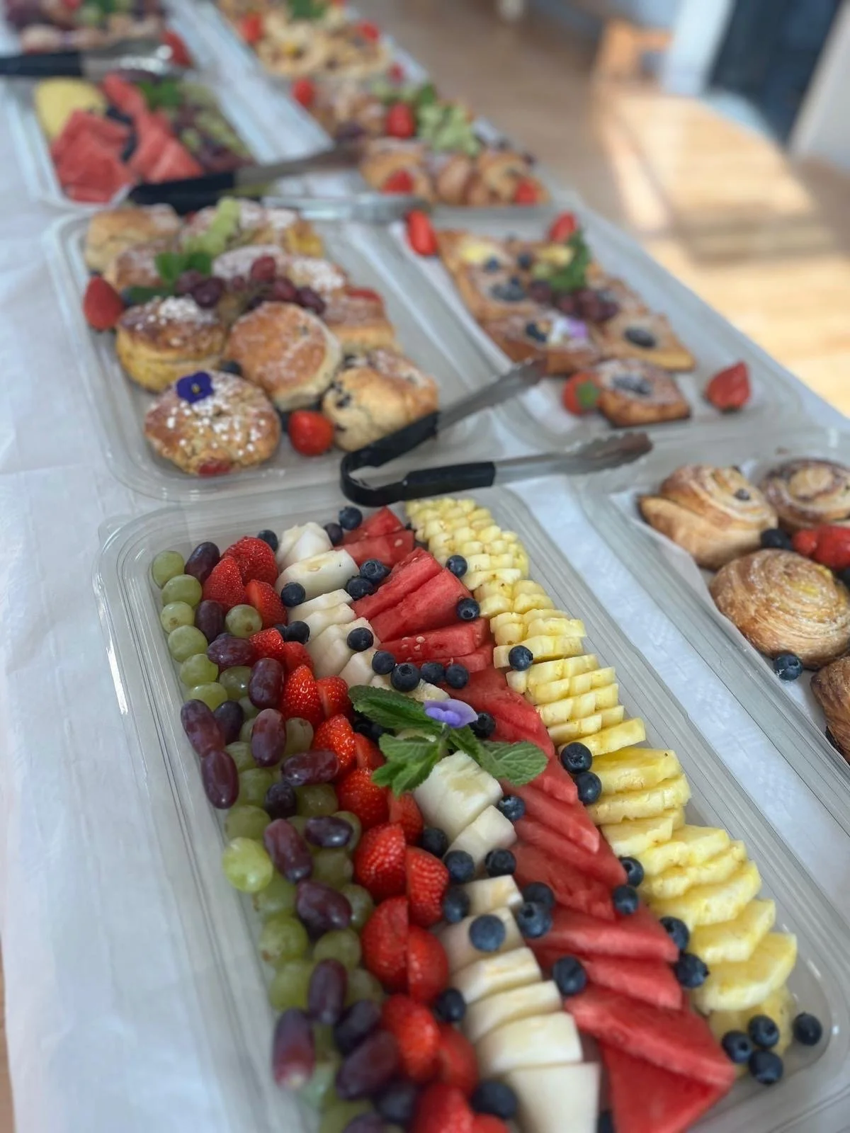 Vivid fruit platter with watermelon, cantaloupe, strawberries, blueberries, grapes, and a sprig of mint.