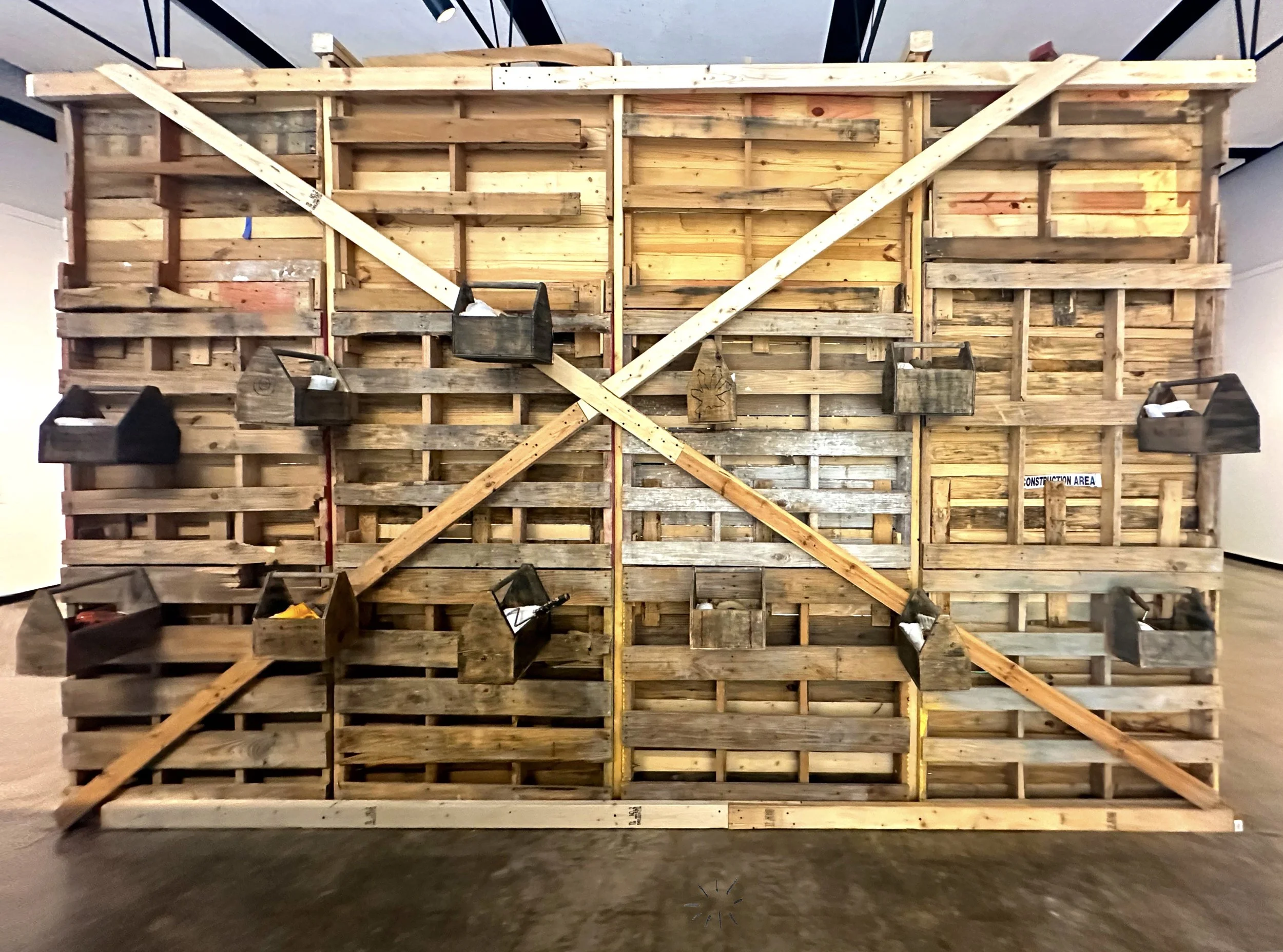Tool Boxes of Memory, 2024-2025. 12 wooden toolboxes, found construction tools, 15x10x2 ft.