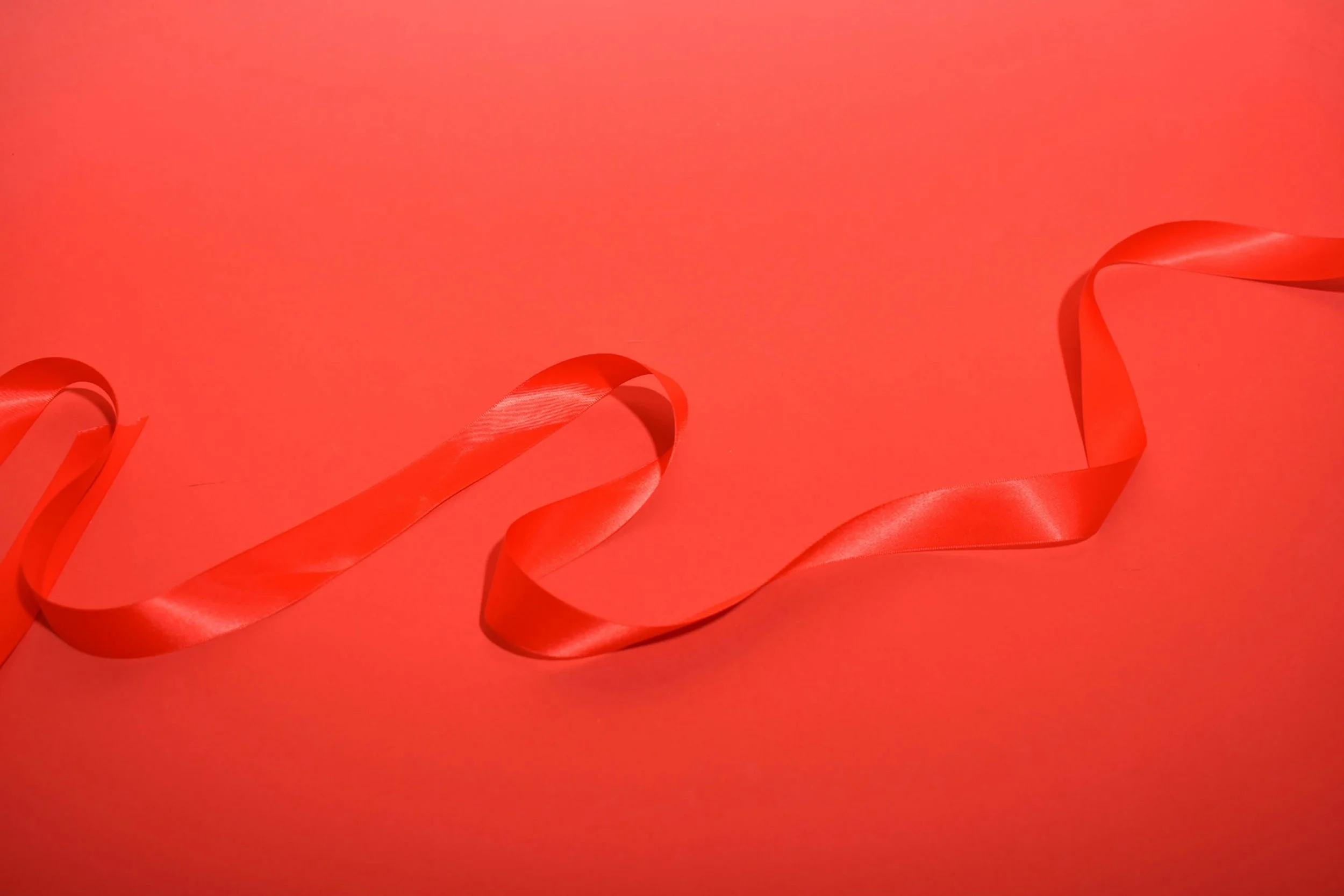 Red satin ribbon on a red background.