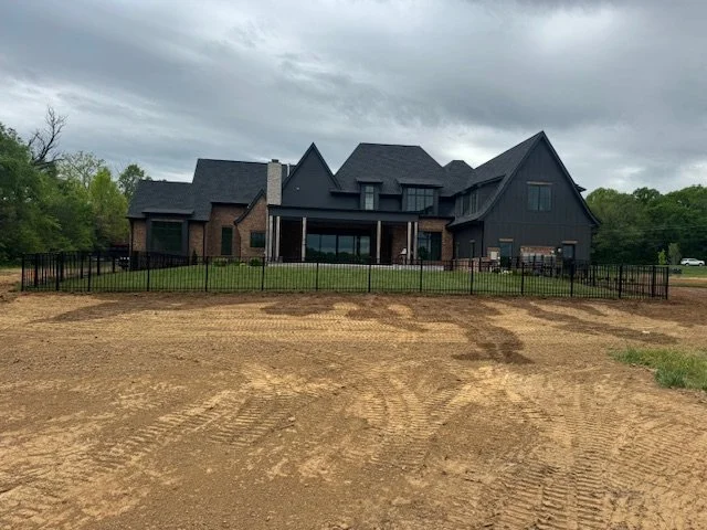 Black aluminum fence enclosing the rear yard of a large custom home in Middle Tennessee