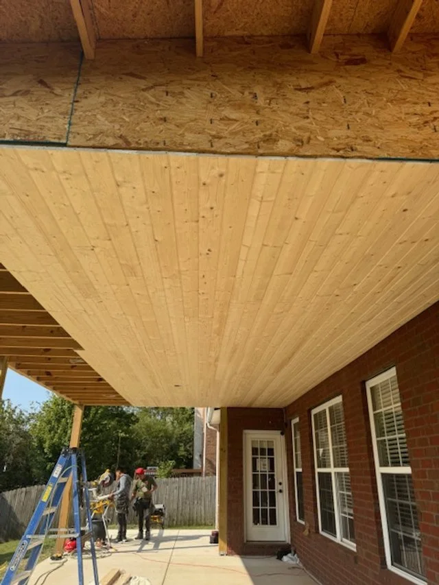 Framed porch ceiling with exposed wood decking during construction