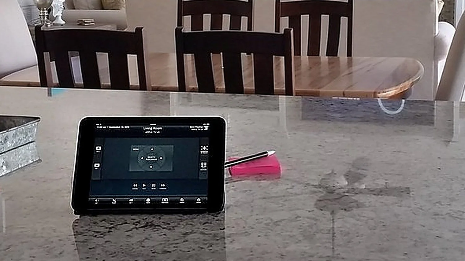 Home control tablet on a kitchen island showing the living room audio-video controls