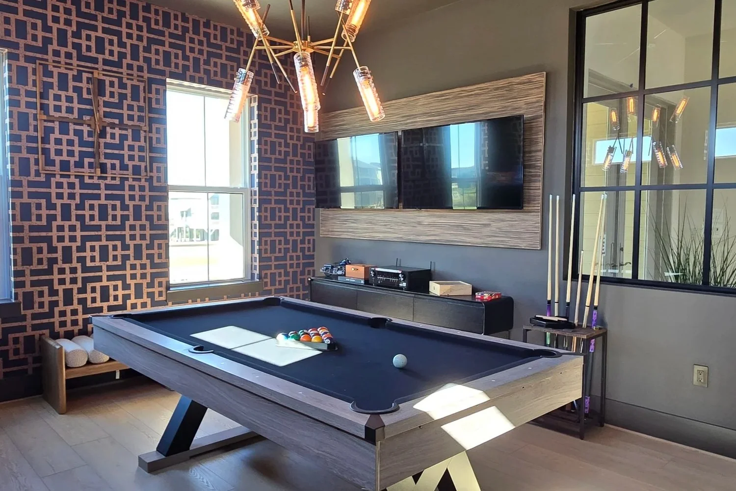 Game room with a pool table and wall-mounted TVs