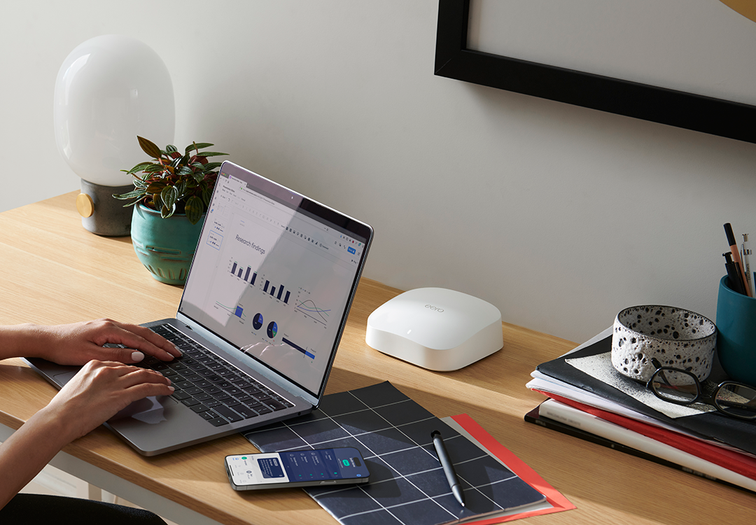 eero router and app monitoring a home network on a desk.
