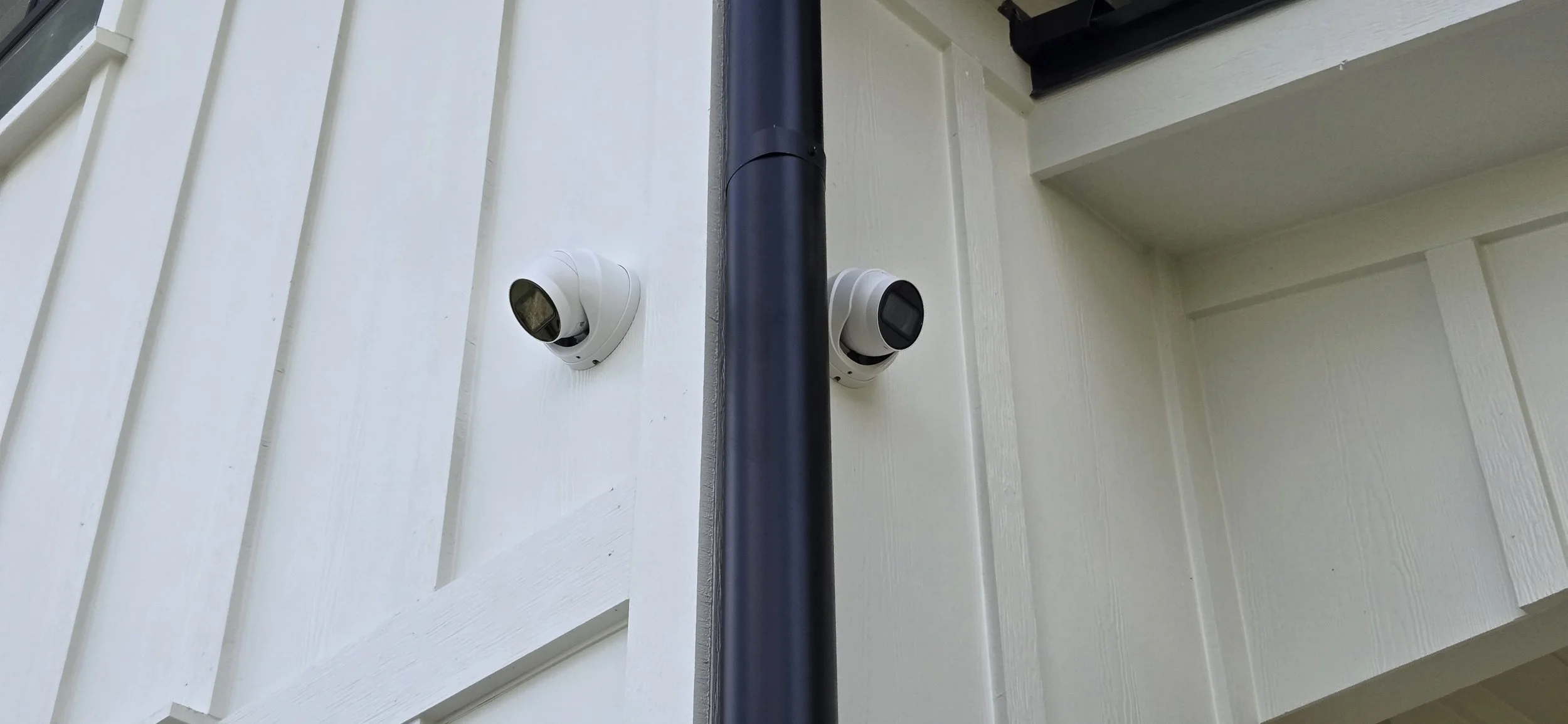 Two security cameras mounted on the exterior of a Magnolia, TX home