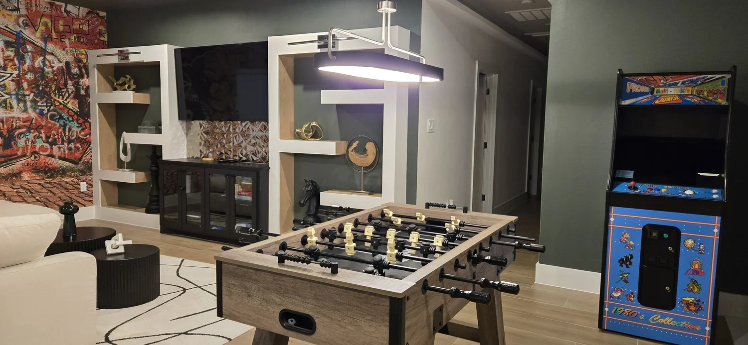 Guest game room with a wall-mounted TV set into built-in shelving
