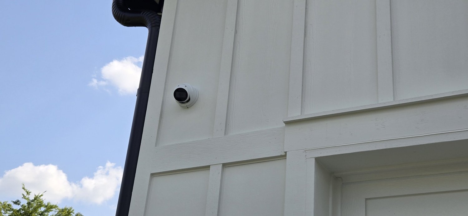 Security cameras mounted on the exterior of an estate home