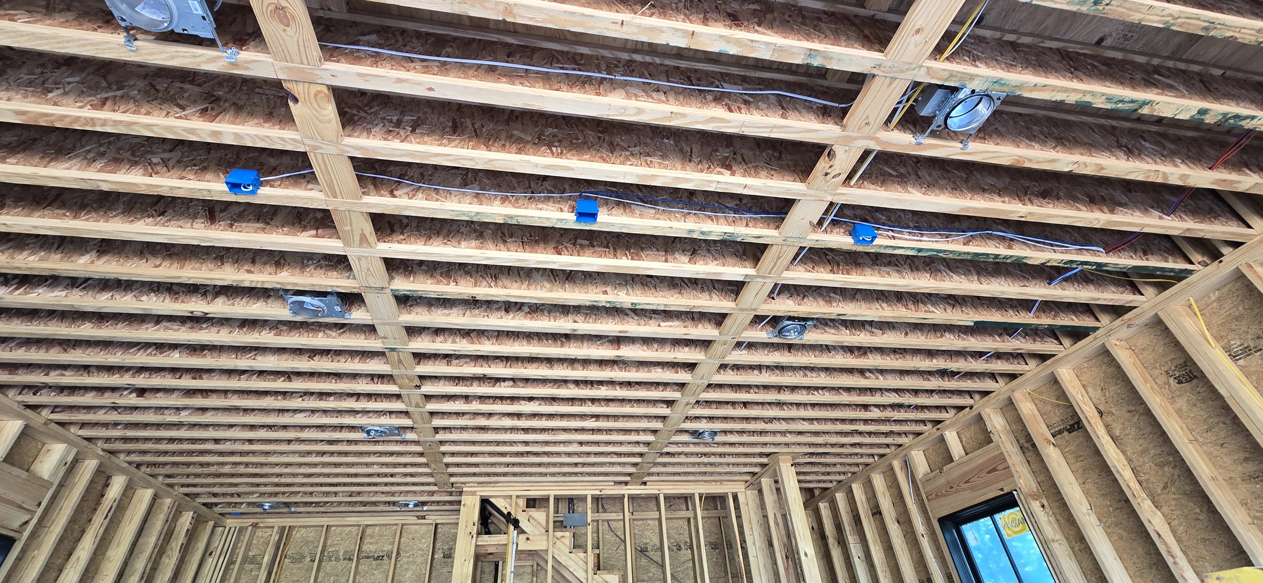 Low-voltage wire runs through open ceiling framing during shop pre-wire