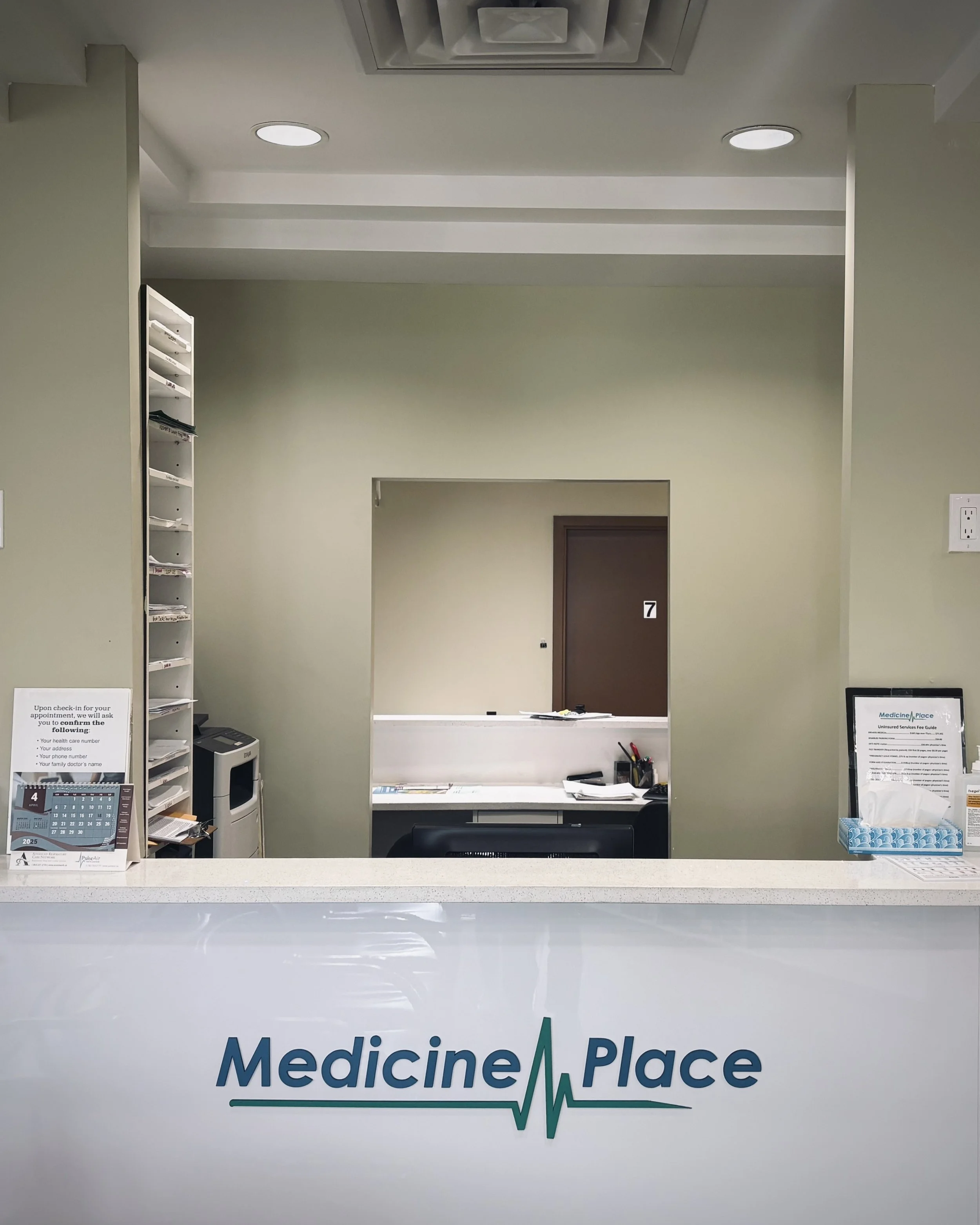 Reception area of Medicine Place clinic with a counter displaying the clinic's name and a heartbeat line logo.