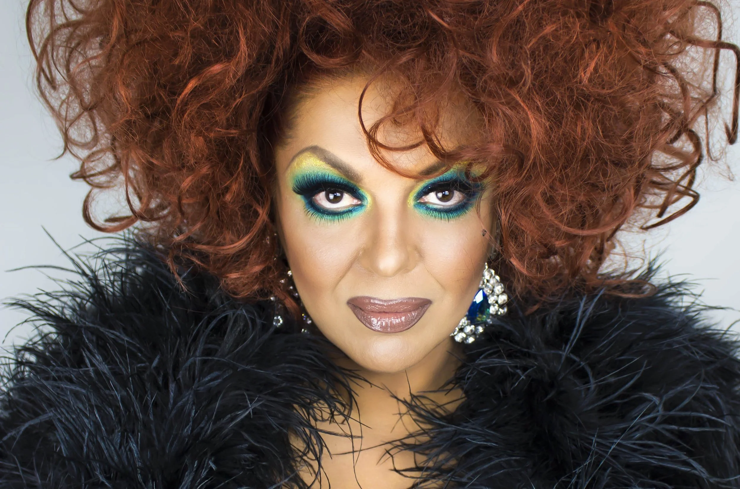 Drag queen in brigh red wig with sparkle dress and red fur