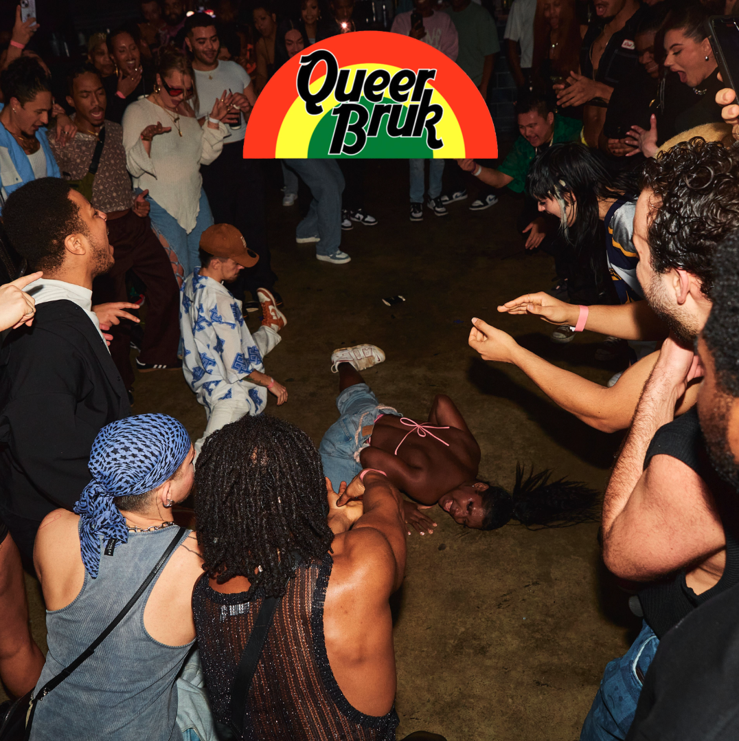 Person wearing a hat and glasses with multiple award ribbons, holding a riding crop, posing against a white background.