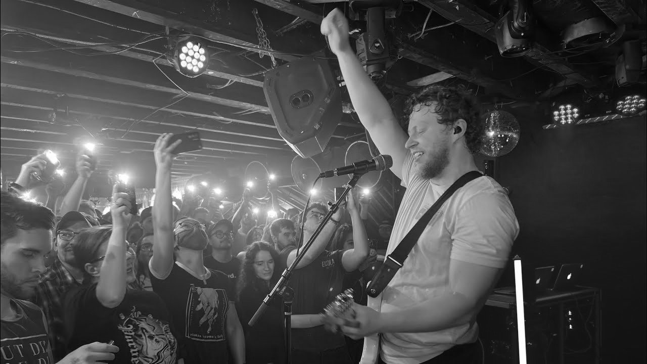Live band performing to a crowd inside an independent music venue