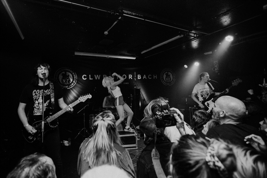 Band performing live on stage in a crowded independent music venue