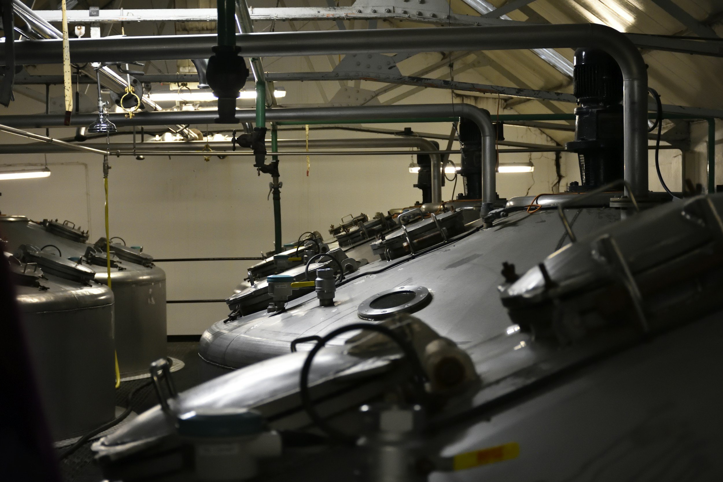 Industrial tanks with pipes, gauges, and valves in a factory or processing plant.