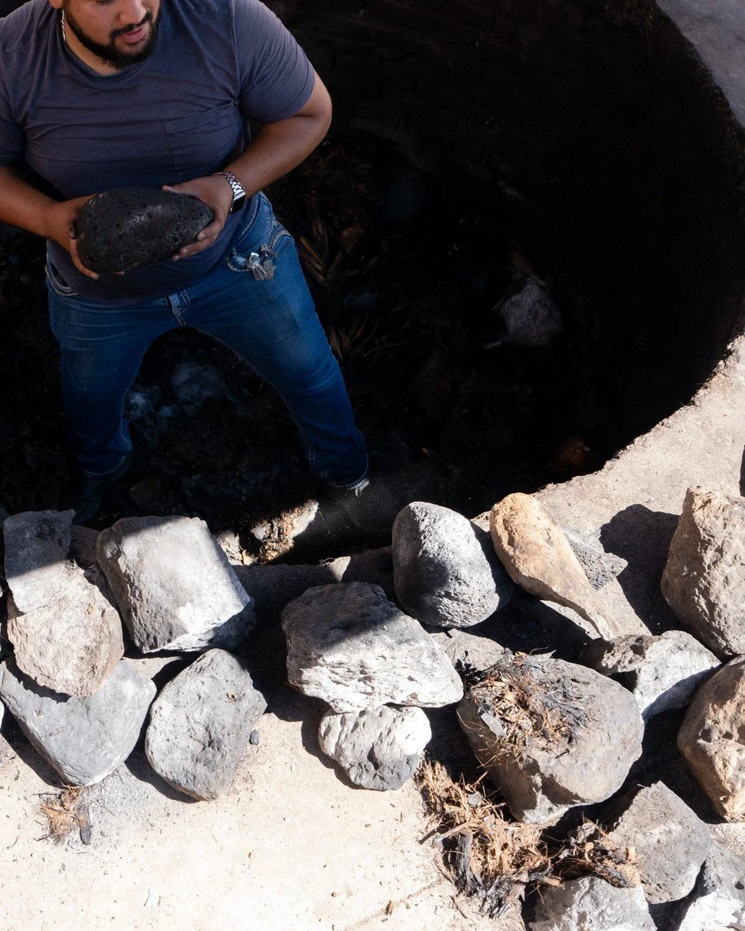 What gives Tall Texan sotol its signature minerality? One part of the answer: three days of slow cooking at Casa Ruelas in Aldama, Chihuahua.

This first picture shows Master Solotero Gerardo Ruelas preparing the earthen pit with volcanic rocks and p