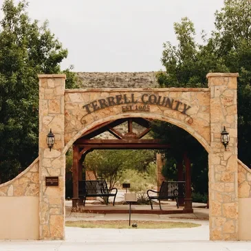 Entrance sign for Terrell County, established 1906, with stone archway and benches underneath