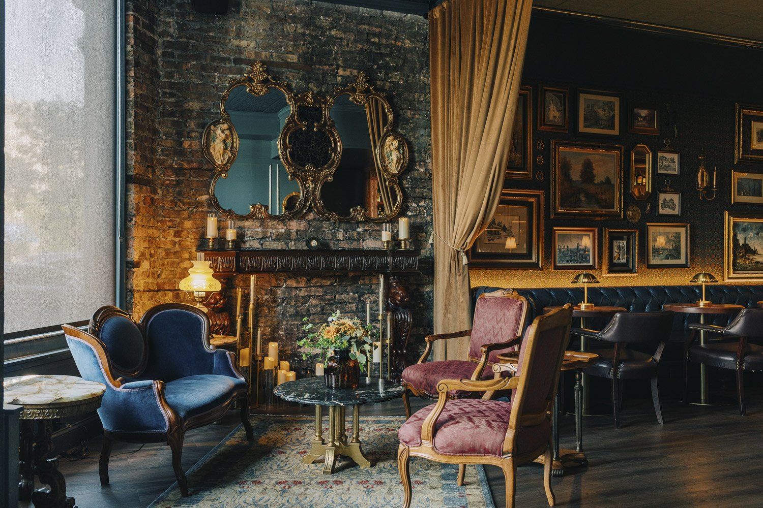 Sitting area at The Mette with vintage furniture, drapery and exposed brick
