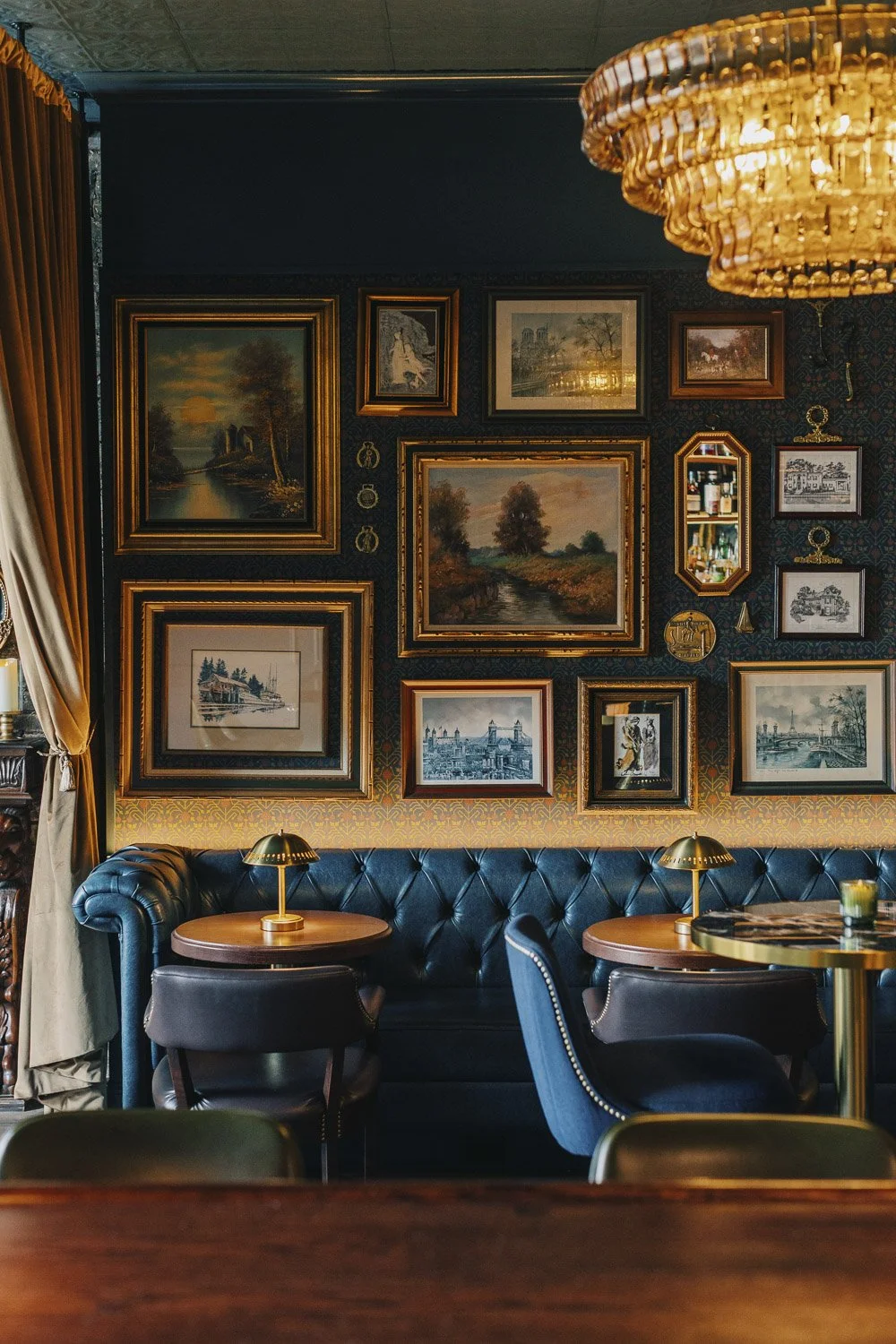 Vintage-inspired chandelier, gallery wall, curtain, and dining area at the