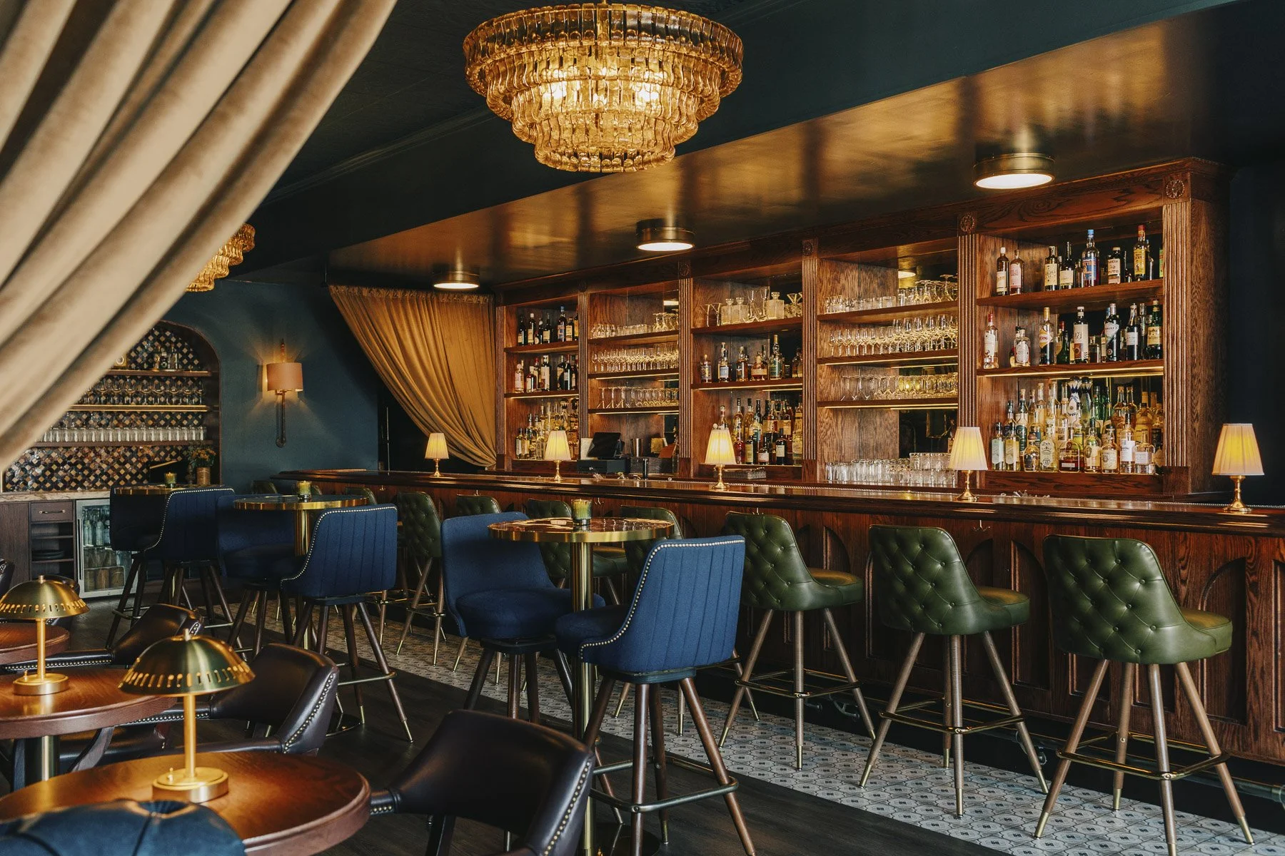 The Mette cocktail bar in Wilmette, Illinois, with the bar, chandelier, and dining table in view