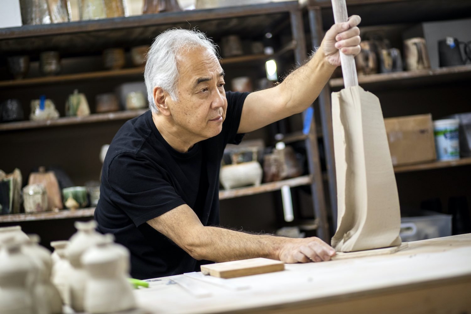 Ceramist Akiro Satake works with clay in his studio.