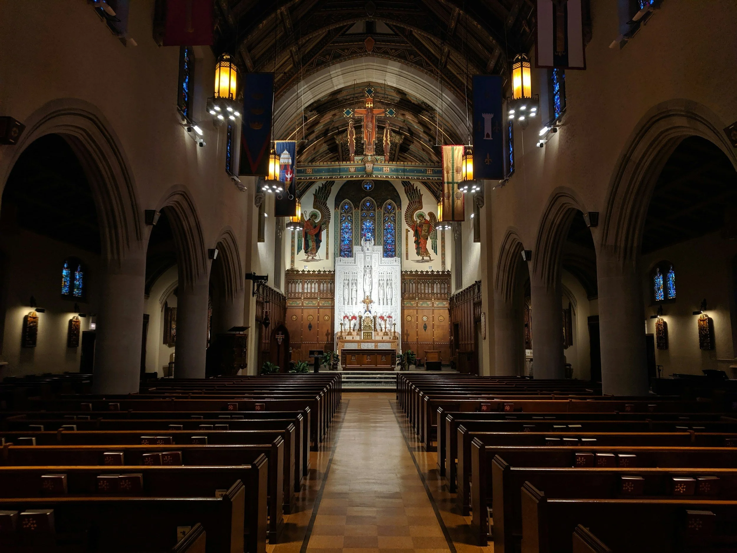 Interior of a Catholic church with wooden pews and stained glass