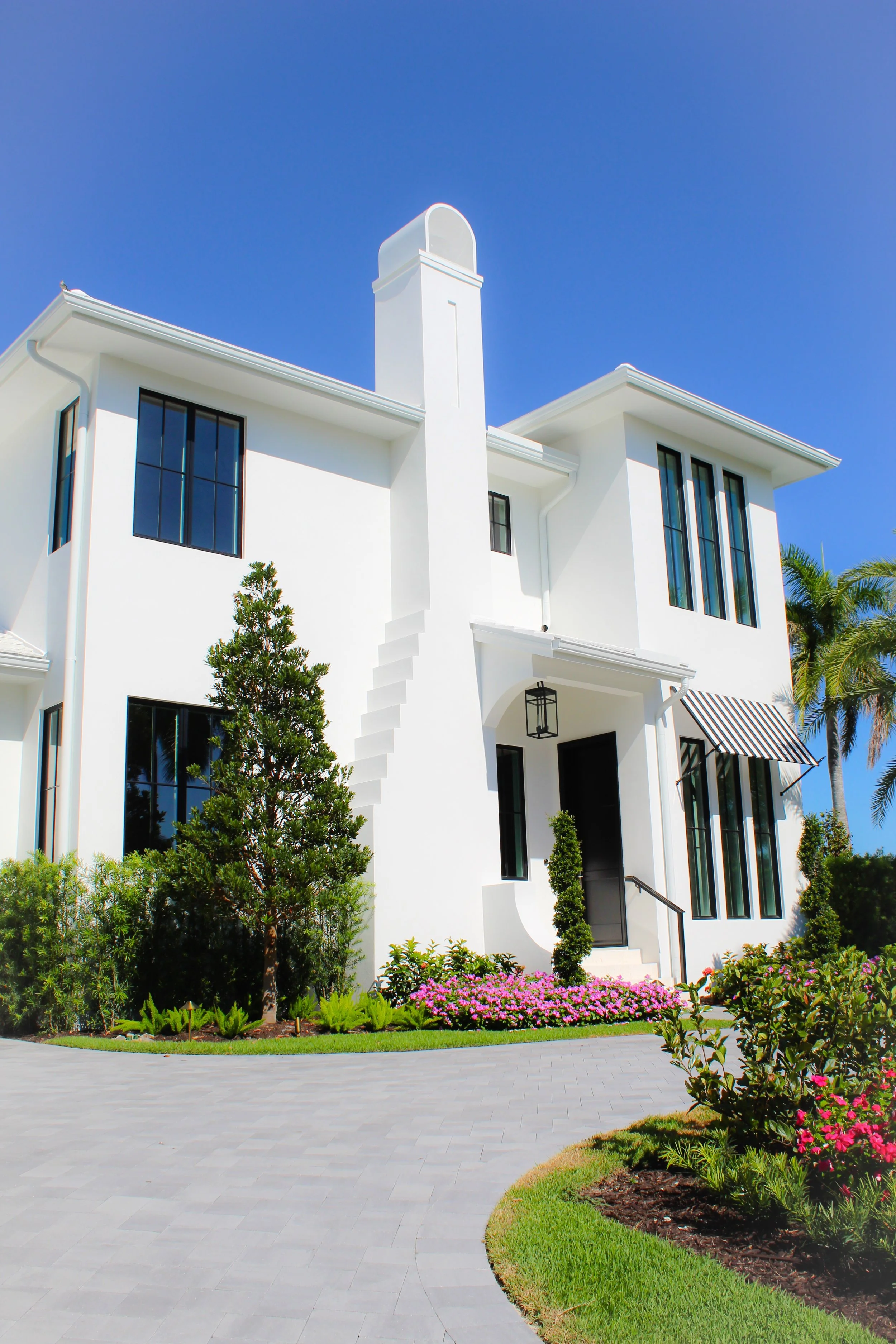 A white modern two-story house with large windows.