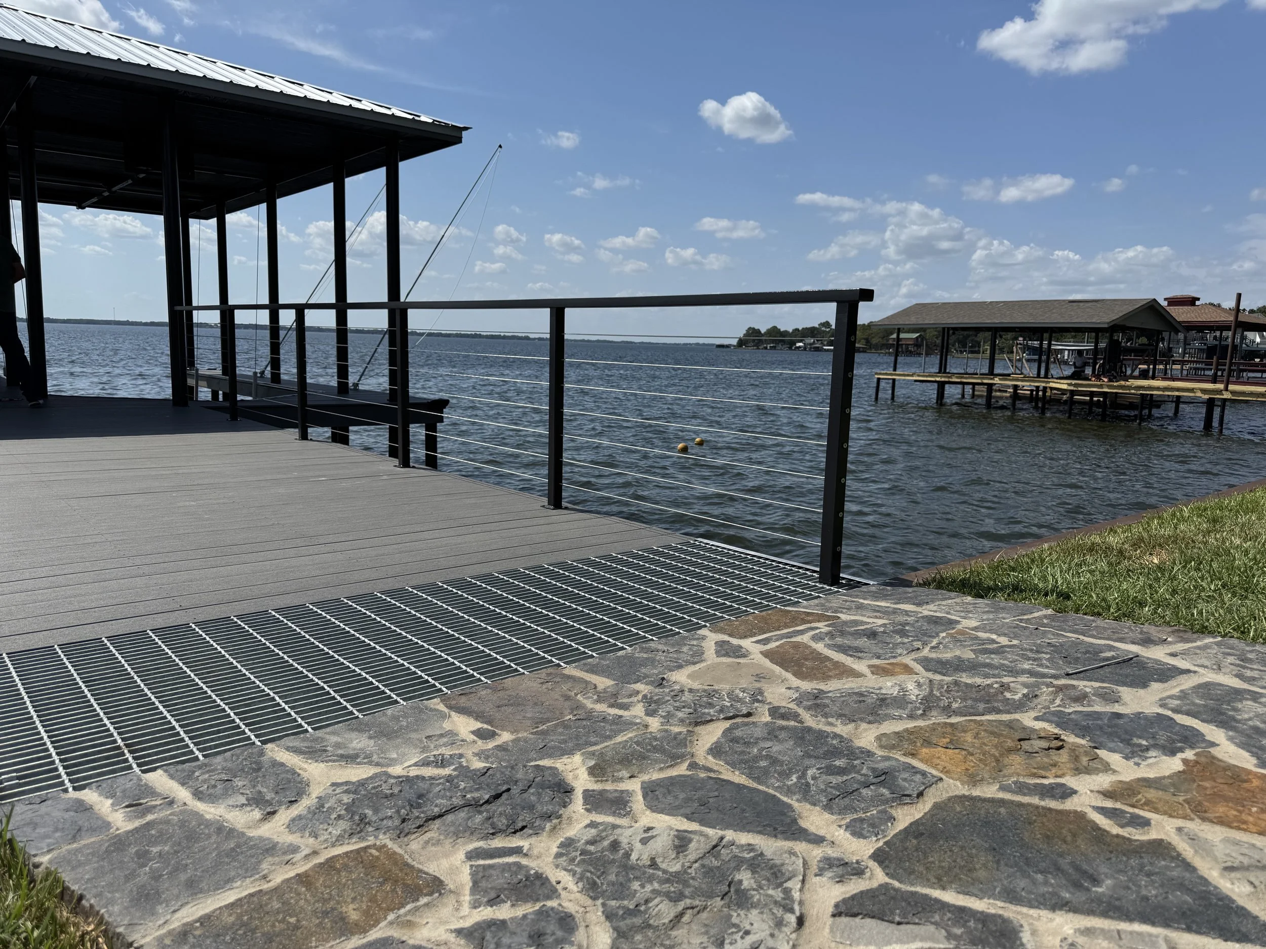 A waterfront deck with a metal railing. 