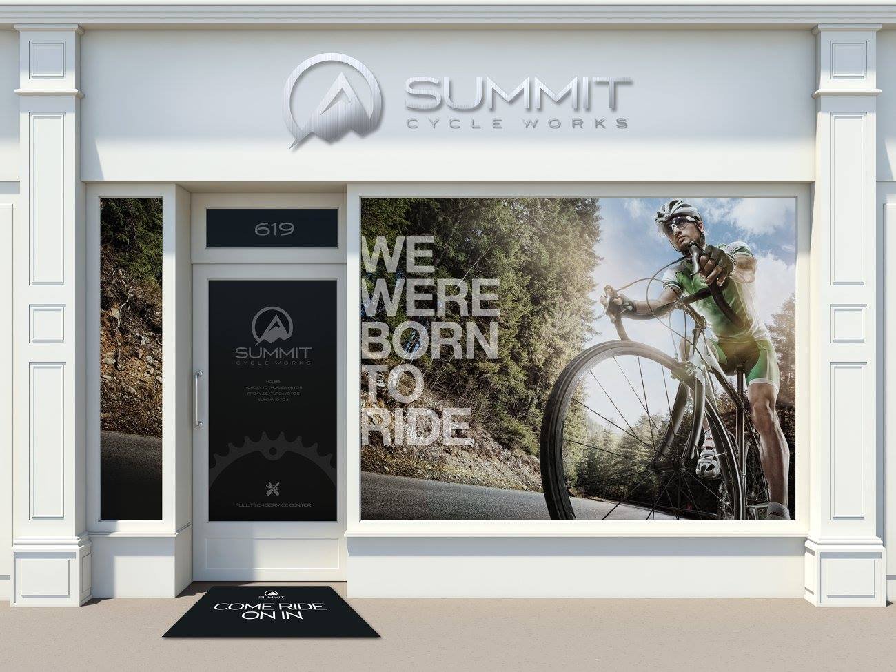 Storefront of Summit Cycle Works with bicycle-themed design, including a large image of a cyclist and the text 'We Were Born to Ride'. Entrance mat reads 'Come Ride On In'. Building includes glass door and large windows.