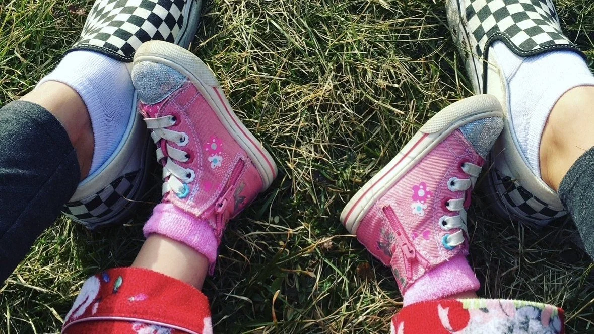 adult shoes surrounding child's shoes