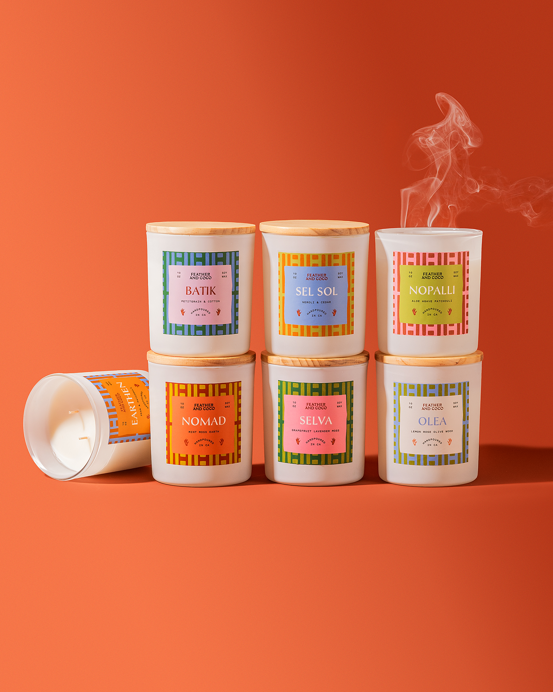 colorful artisan soy candle and diffuser spray packaging with green background