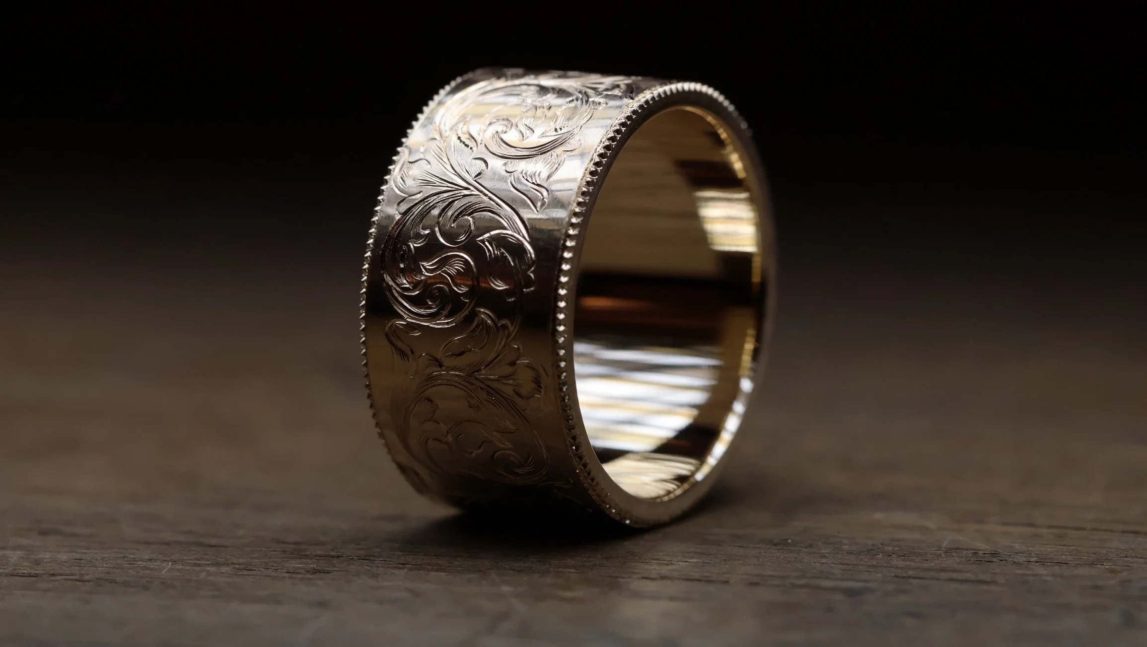 A modern silhouette 9ct wide yellow gold band finished with a timeless, traditional, hand engraving. 
A modern heirloom, to be treasured. 

Created to replace a ring that was lost in the sea, now to have a story of its very own.