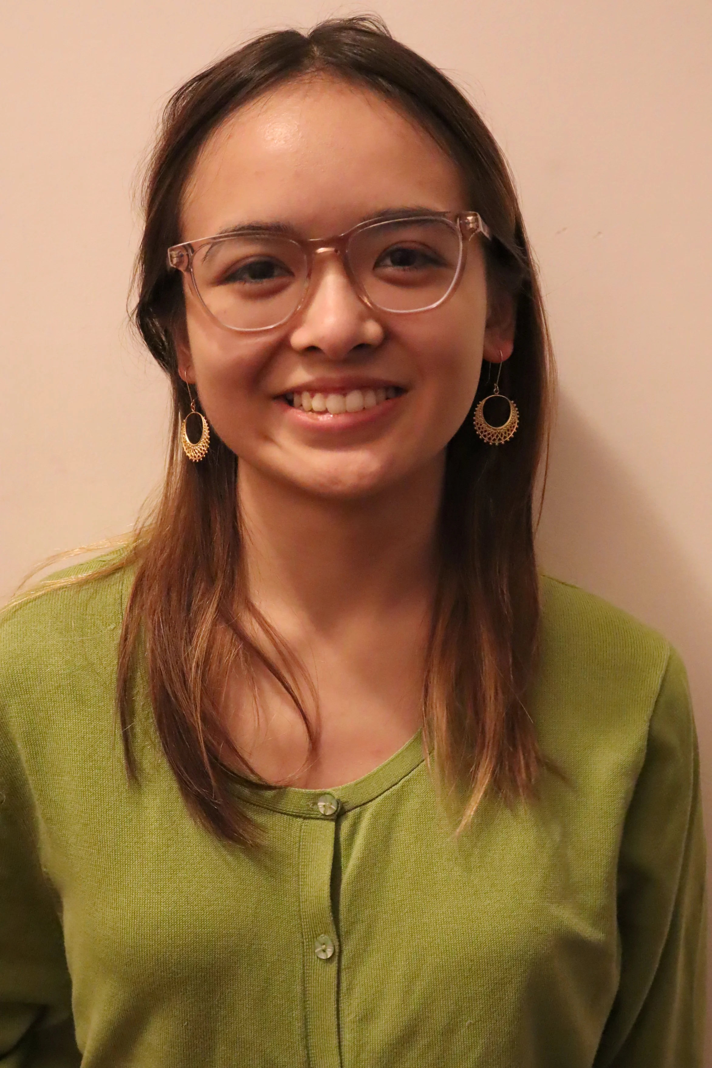 Person wearing glasses and a black sweater with a dragon design.