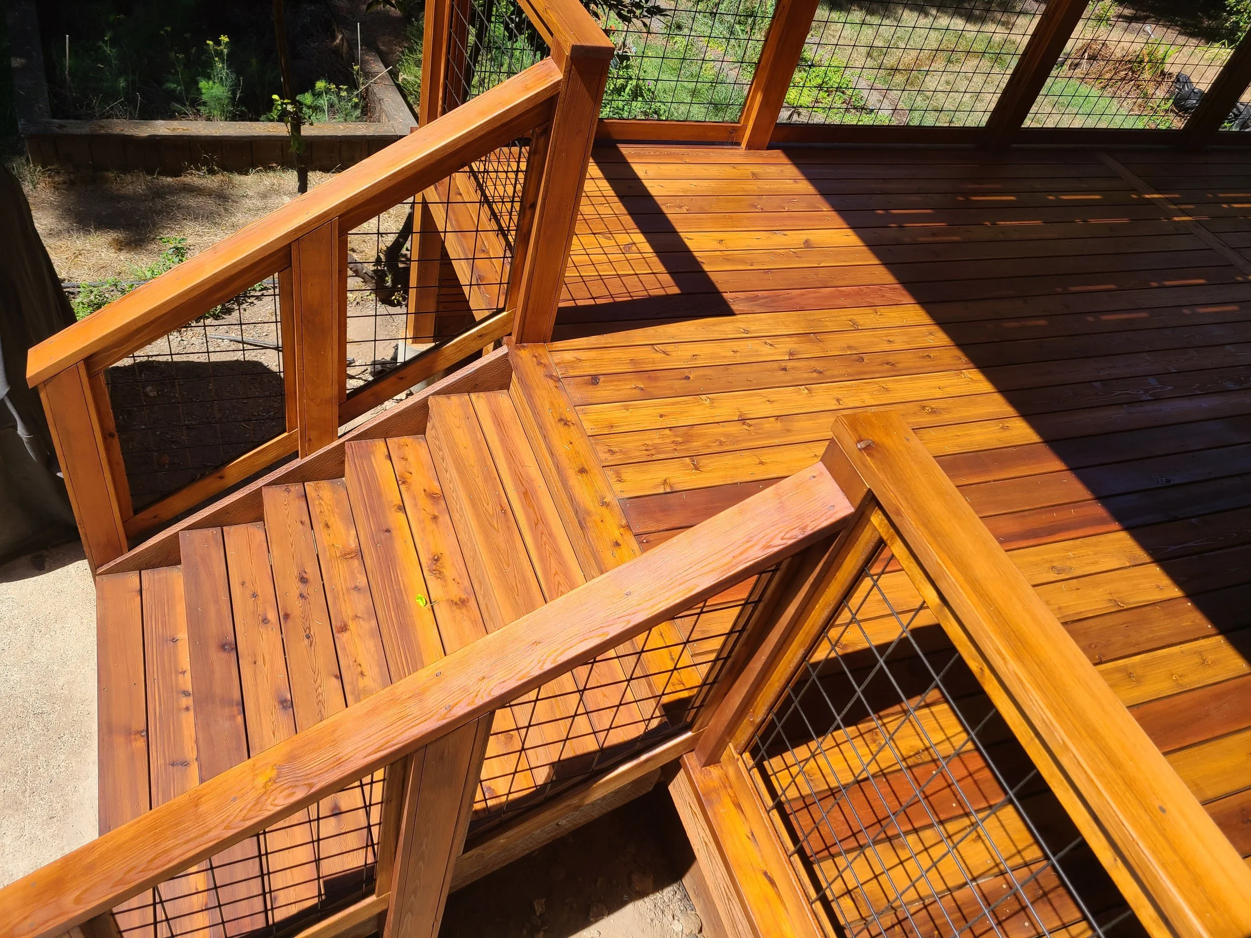 Rich stained cedar deck with wire grid framed railing