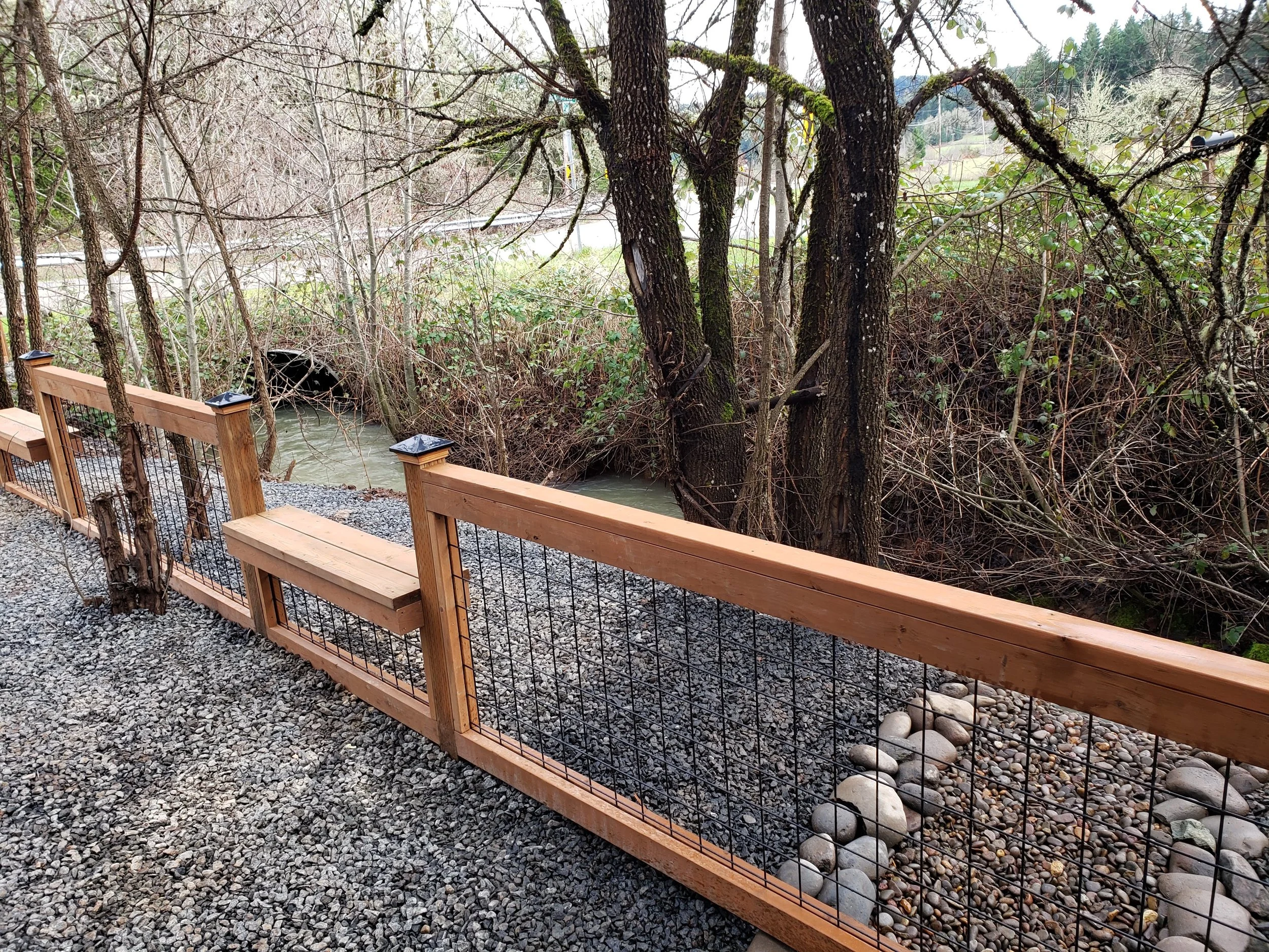 A custom wire panel fence with integrated bench seating, blending functionality with natural views.