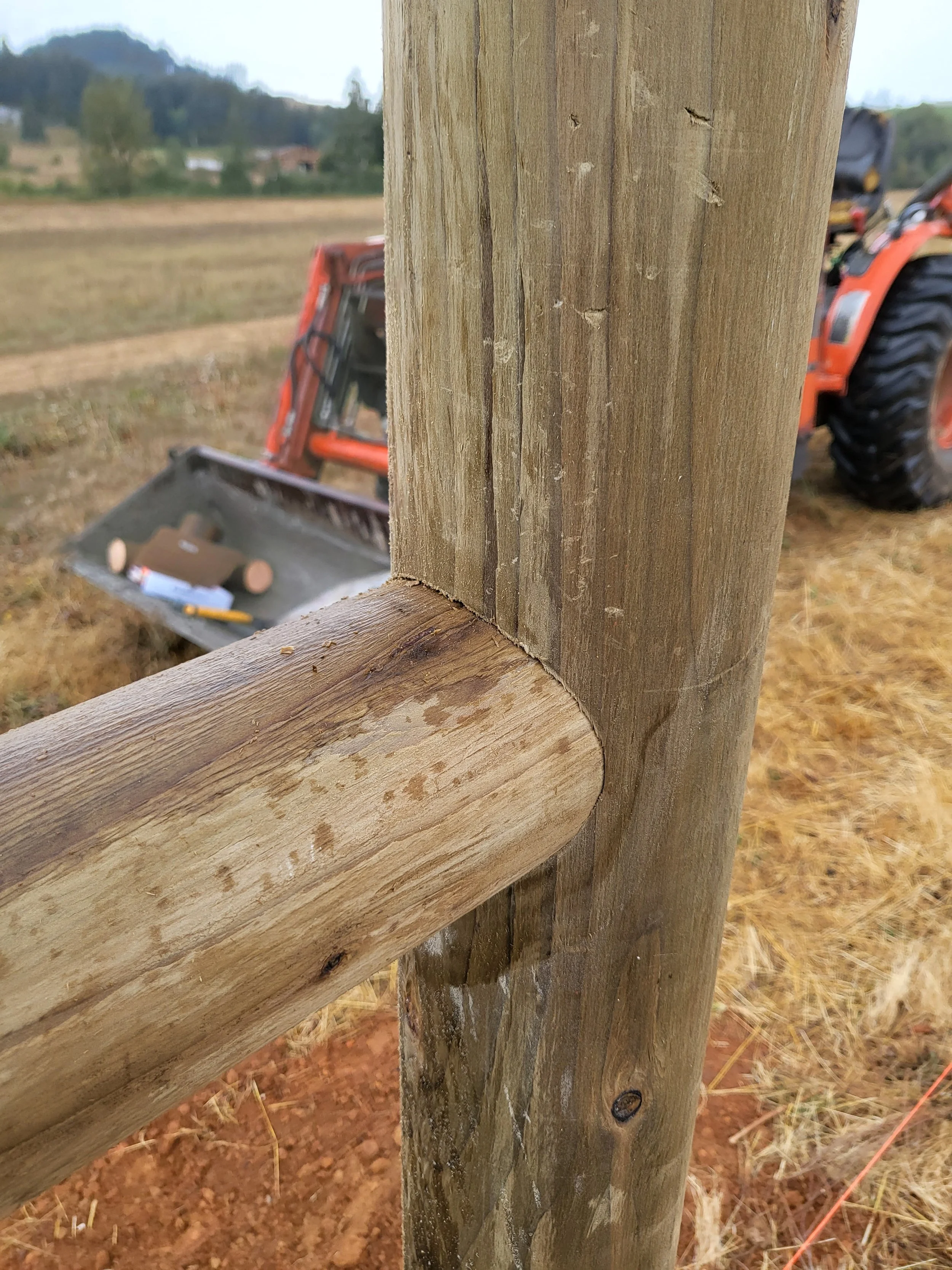 Close-up view of a hand-cut round rail fence connection, showcasing durability and precision joinery.