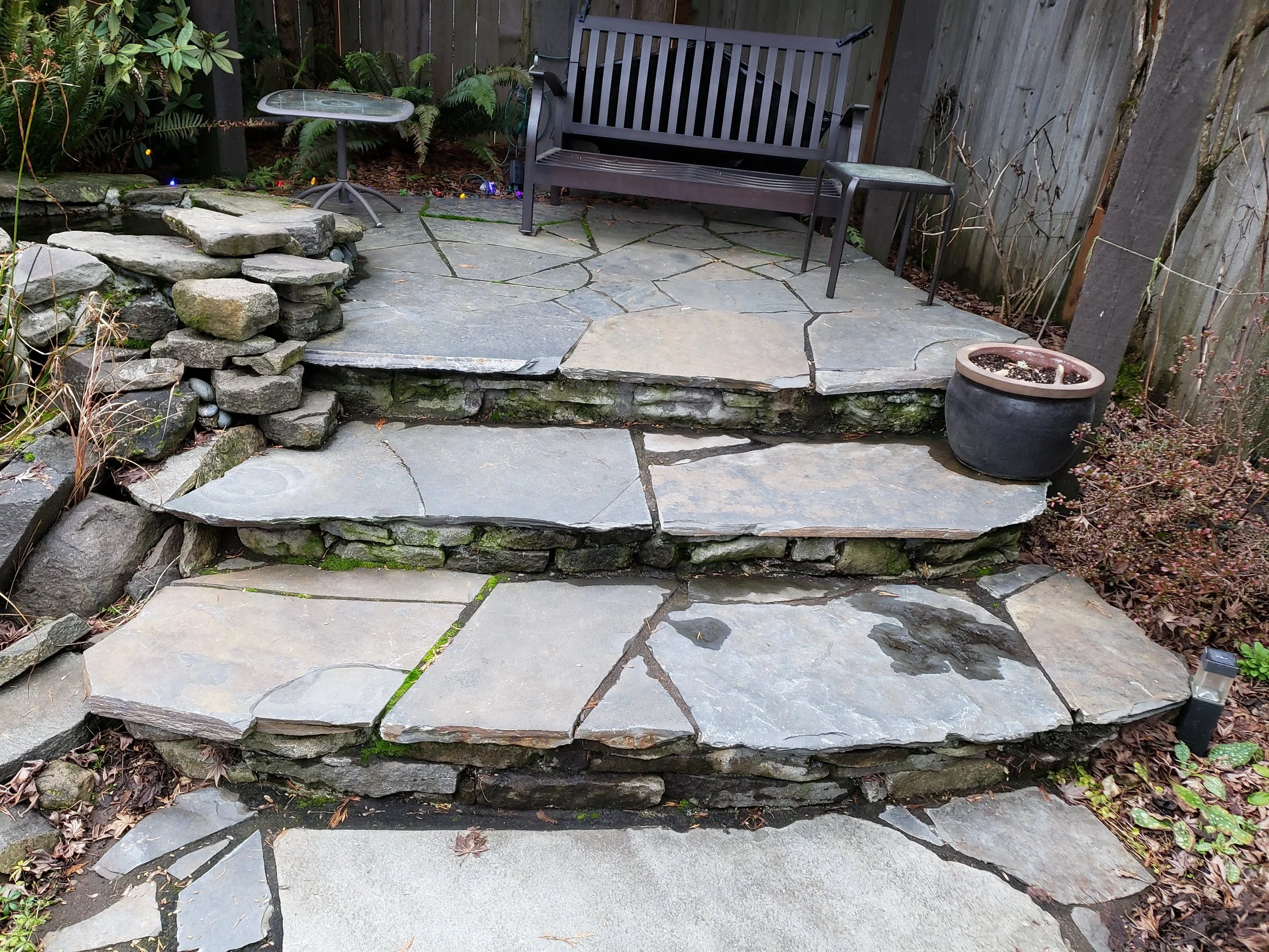 Natural stone steps leading to a cozy patio, designed for beauty and long-lasting use.