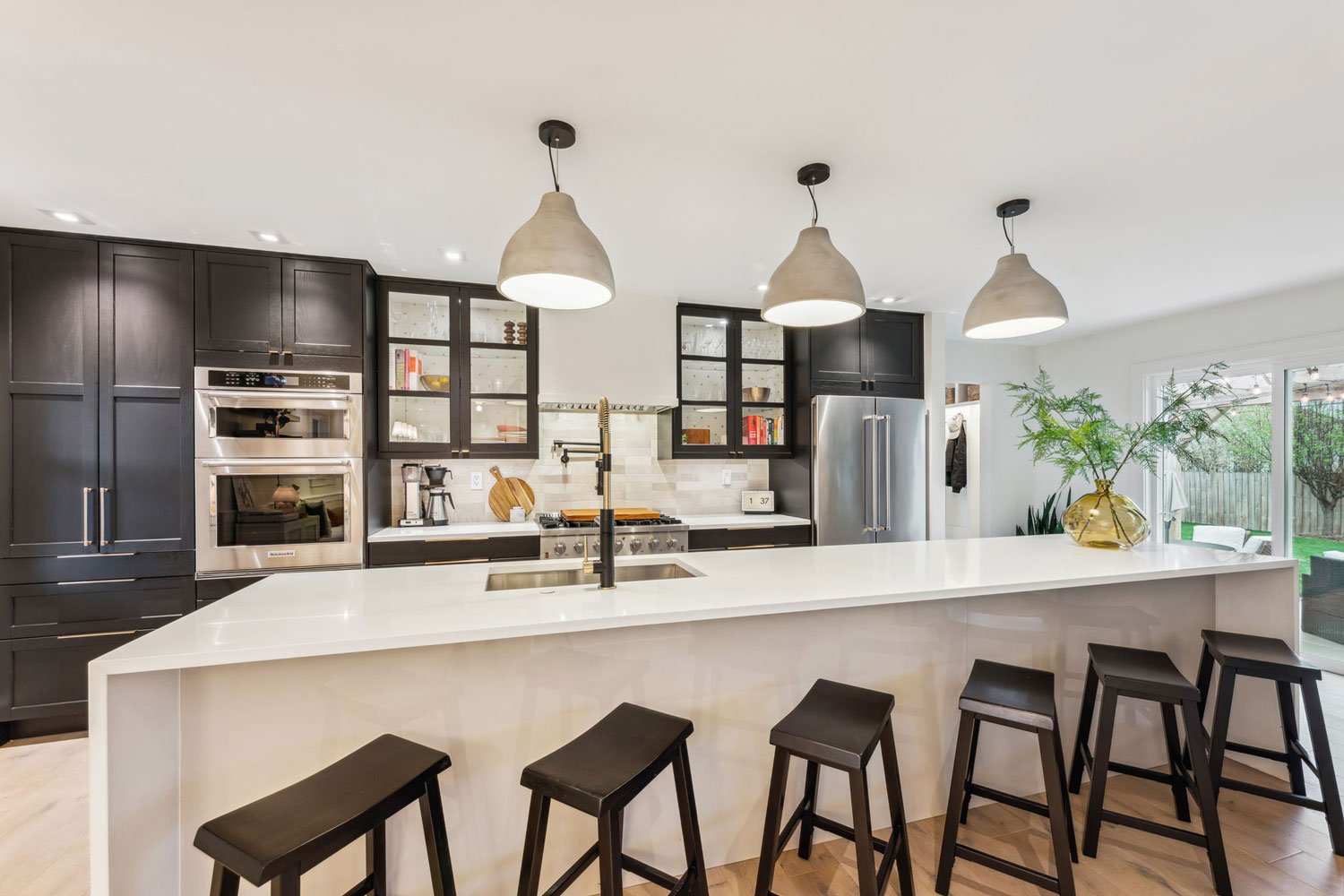 renovated kitchen with stools, counter, backsplash and appliances in upper arlington ohio