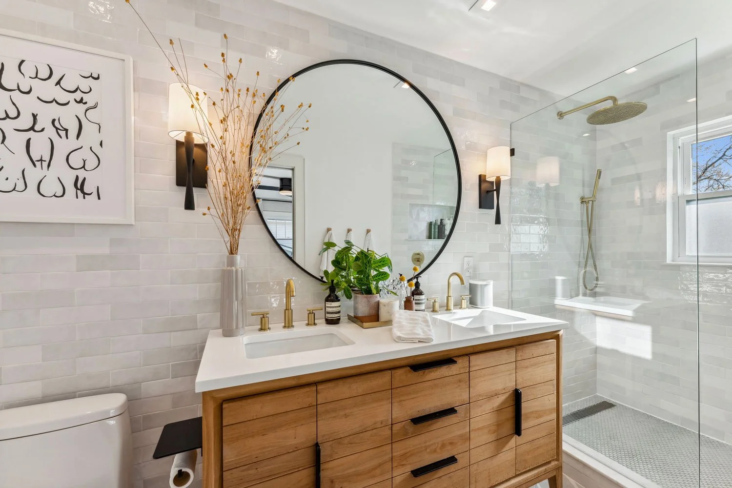 remodeled primary bathroom with tile wall, new mirror, brass fixtures, teak vanity in columbus ohio