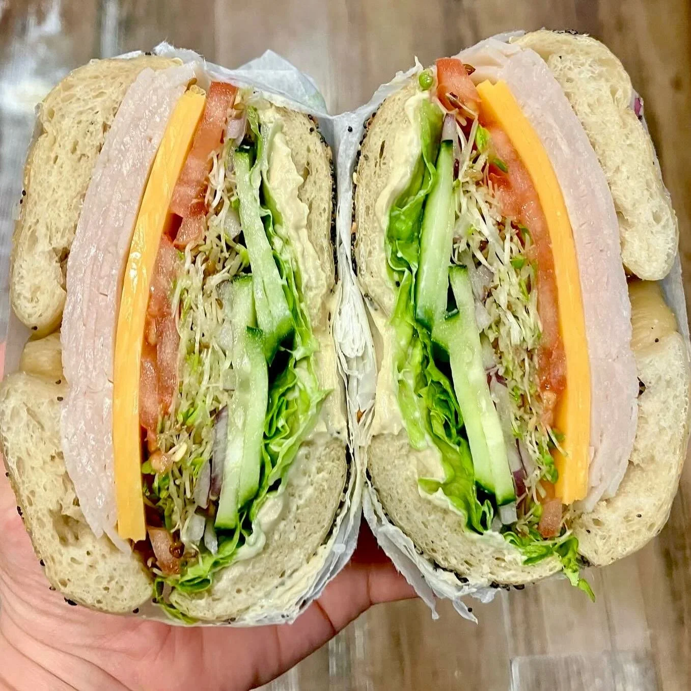 Back to regular hours today!
Get a sammie to start the year off right. This cutie is on a toasted everything bagel with ham, cheddar, tomato, sprouts, cuke, lettuce, red onion and hummus.