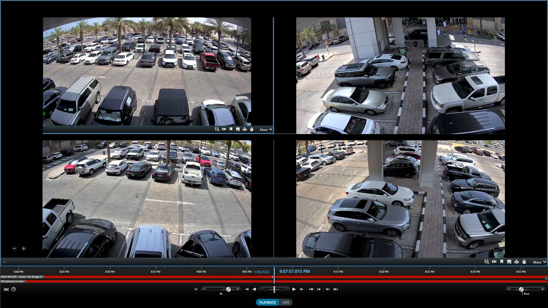 Multiple security camera feeds showing parking lots with numerous parked cars, trees, and an urban environment.