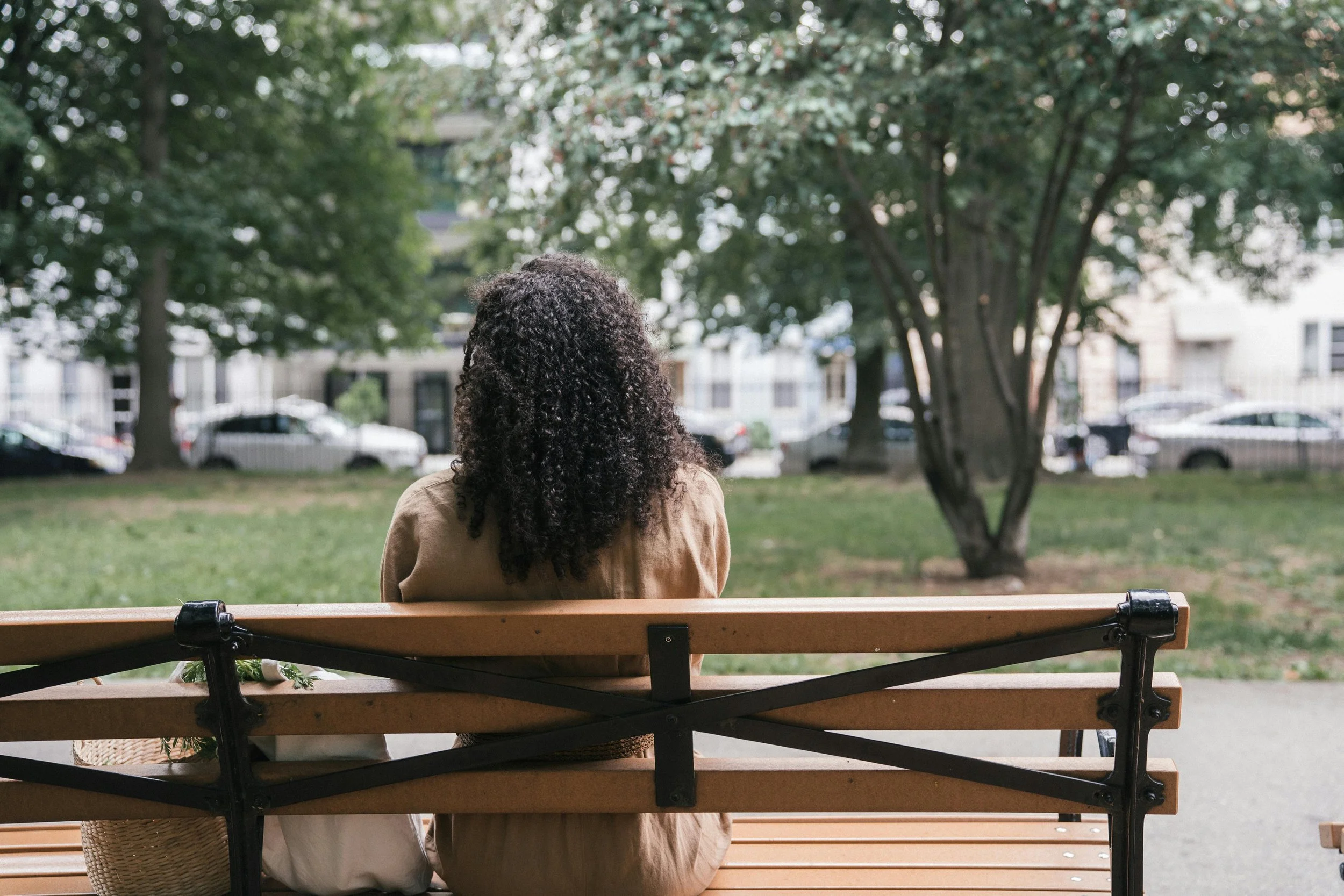 Silent grief of friendship breakups — Black woman sitting alone on a park bench