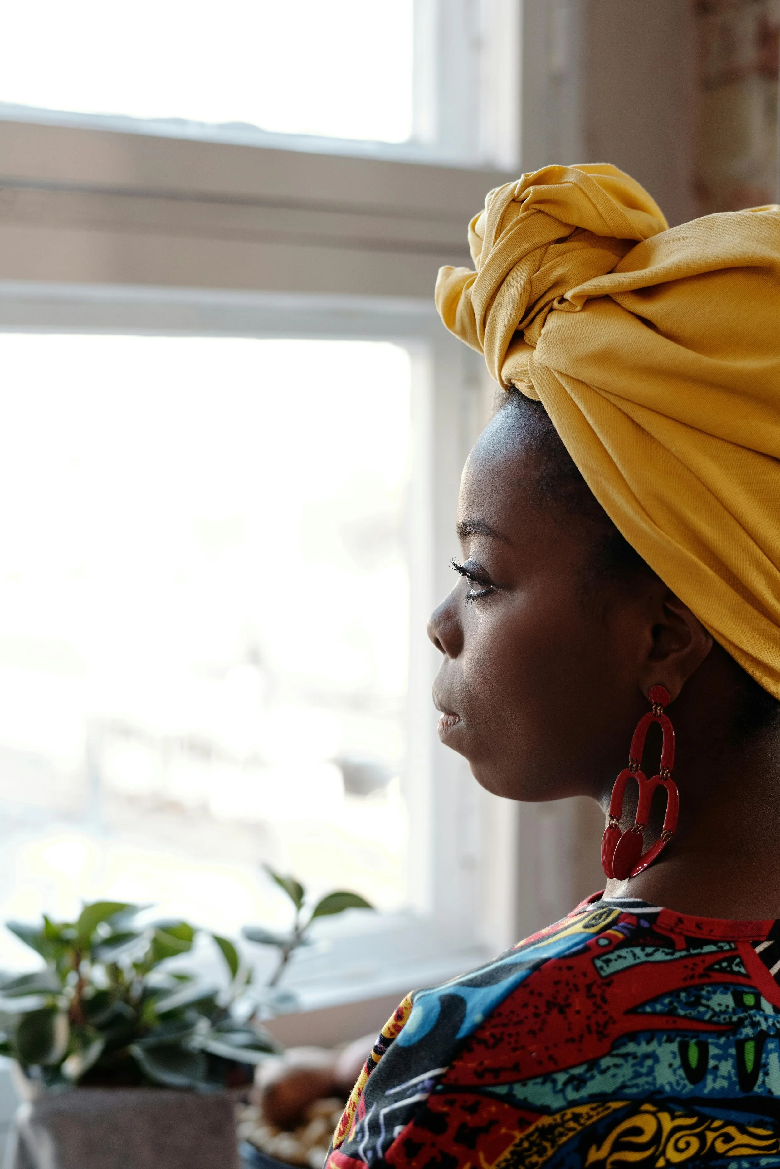 Woman looking out a window while reflecting on emotional healing after betrayal, relationship trauma, and personal growth.