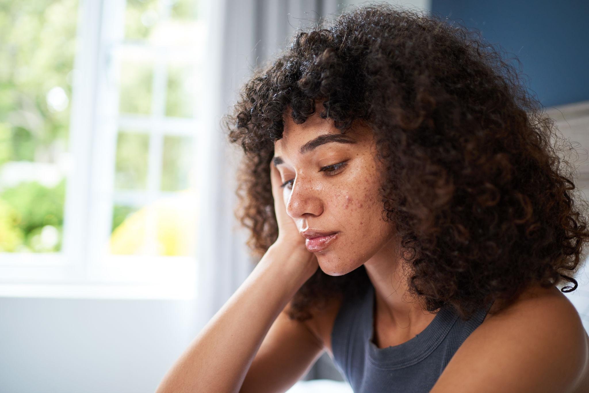 Woman experiencing emotional overwhelm and self-blame, reflecting on anxiety and trauma patterns