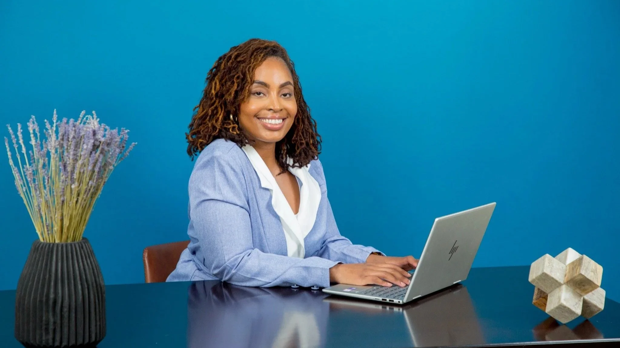 Katrina Wilkes, LCSW, seated at her desk providing virtual trauma-informed therapy for women.