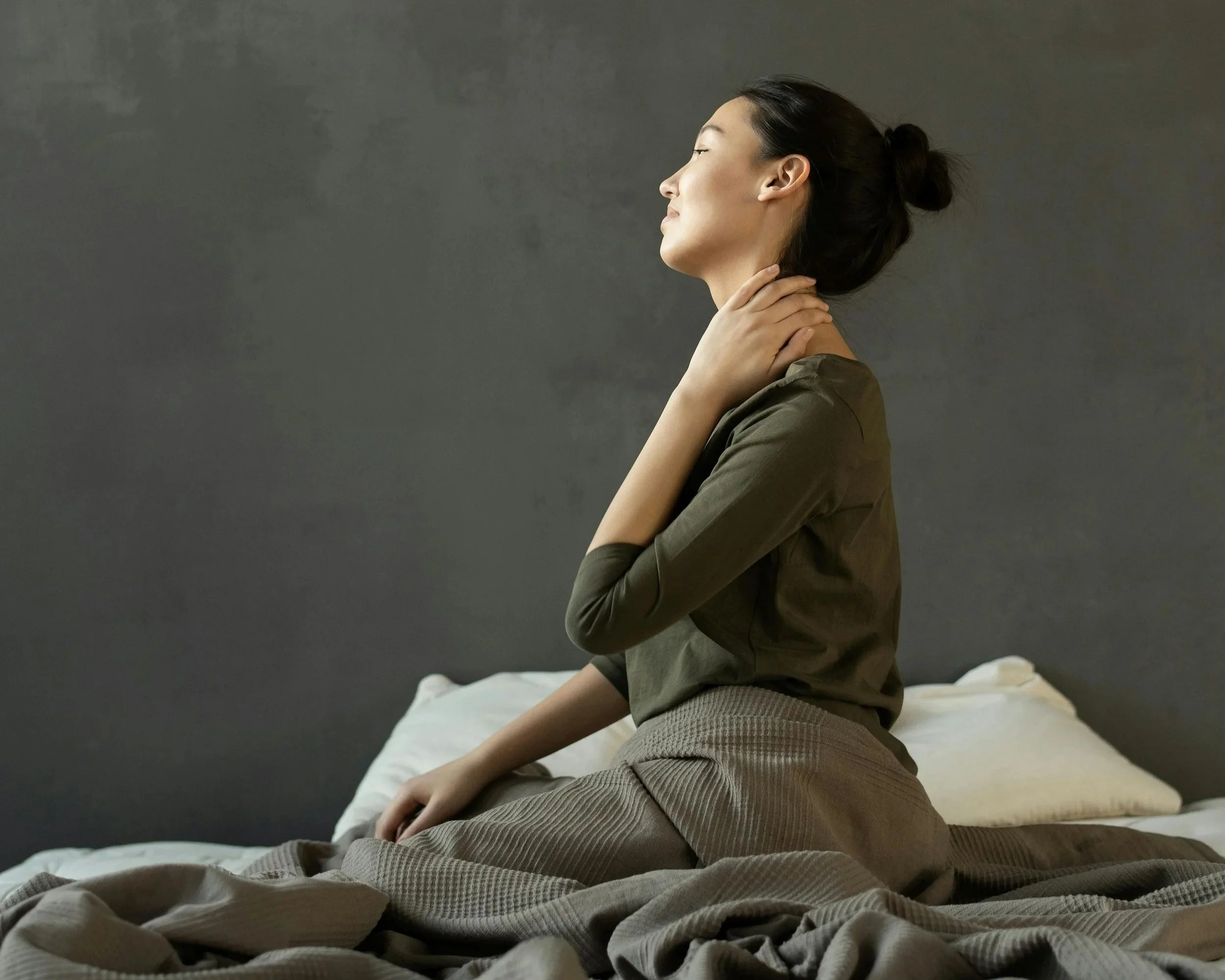 Over-functioning exhaustion — high-achieving woman with hand to neck carrying invisible weight